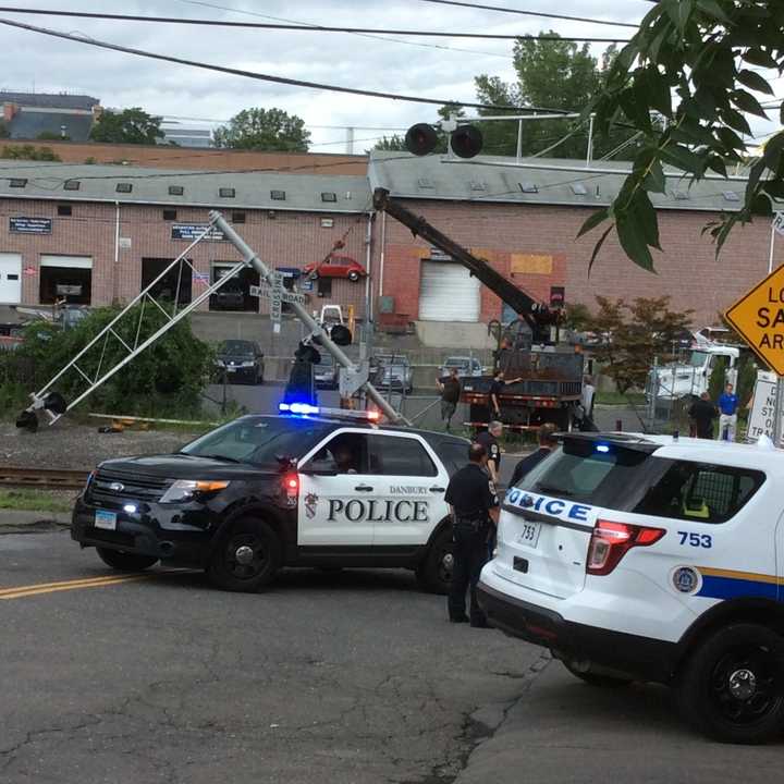 Police on scene of a damaged grade crossing where a car hit a gate in Danbury.