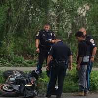 <p>Danbury police officers and the motorcyclist examine the crash scene Tuesday on Town Hill Avenue.</p>