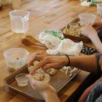 <p>Someone seals filling inside a dumpling wrapper.</p>