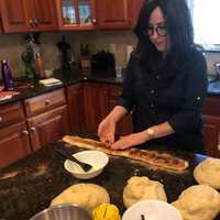 <p>Step 10: Kaminker rolls each piece into a long rope and flattens it before sprinkling with cinnamon-sugar and raisins. She pinches the dough shut so it once again looks like a more round strand before shaping.</p>