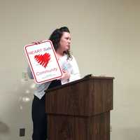 <p>State HEARTSafe Coordinator Michele Connelly displays the signs that will be placed around Fairfield.</p>