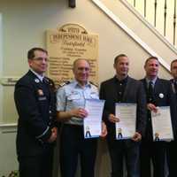 <p>Evan Tilley, second from left, Sam Mouziyk, center, and Firefighter Jerry McGuire, second from right, pose with their proclamations.</p>