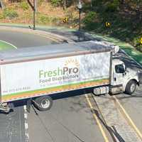 <p>A driver from All Points Towing (in orange vest) helped get the FreshPro Distributors truck out.</p>