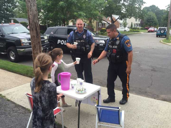 Fair Lawn police officers Tim Ammann, left, and Luis Vazquez say their day was made by Yocheved and Ahuva&#x27;s lemonade stand.