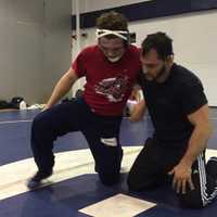 <p>Bonino and Paramus wrestling coach Chris Falato work through moves on the mat.</p>