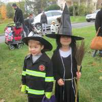 <p>A firefighter and a witch march in the Briarcliff Ragamuffin Parade.</p>
