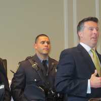 <p>Rye Commissioner Michael C. Corcoran Jr. flanked by newly-sworn Rye patrol officers and a firefighter during an earlier ceremony at City Hall. Corcoran has resigned</p>