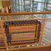 <p>Artist Katherine Daniels created an art installation of colorful plastic strips woven into the gridded surround of Greenwich Library&#x27;s grand stairs.</p>