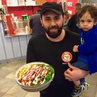 <p>Jaffar Wahdat with son, Ali, in Juicy Platters Hackensack with a grilled chicken green blast meal.</p>