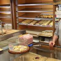 <p>Varrelmann's Co-Owner Michael Fencik holds an apple crumb, another highlight of the bakery. Fencik said he typically recommends the apple crumb when customers are looking for a food to bring to a special occasion.</p>
