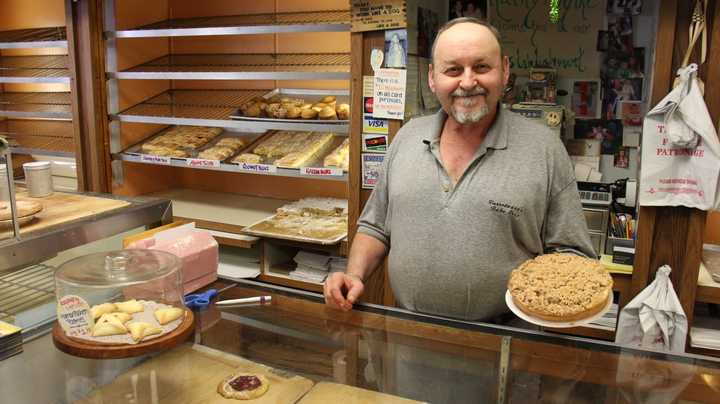 Varrelmann&#x27;s Co-Owner Michael Fencik holds an apple crumb, another highlight of the bakery. Fencik said he typically recommends the apple crumb when customers are looking for a food to bring to a special occasion.