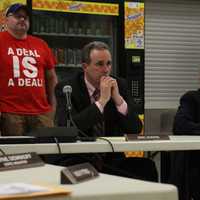 <p>Superintendent Eric Koenig looks on as Board of Education President Edmund DeSantis responds to criticisms of the board.</p>