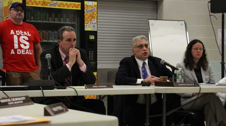 Superintendent Eric Koenig looks on as Board of Education President Edmund DeSantis responds to criticisms of the board.