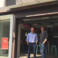 <p>Brenan Hefner, left, and Clayton Bushong, right, partners in Cantinas Lobos in Pelham, stand by the  eatery&#x27;s garage door.</p>