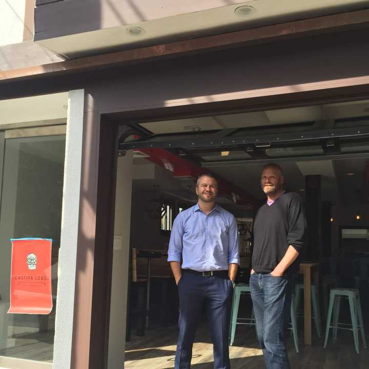 Brenan Hefner, left, and Clayton Bushong, right, partners in Cantinas Lobos in Pelham, stand by the  eatery&#x27;s garage door.