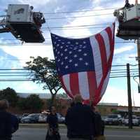 <p>Firefighters raise the American flag over the library.</p>