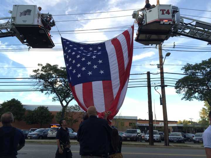 Firefighters raise the American flag over the library.