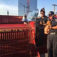 <p>Jackie Calkins and Scott Abascal pose with Scrappy on the Fox, a 1931 firetruck that still runs and pumps.</p>