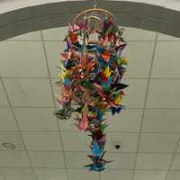 <p>Paper cranes hang from the ceiling at the Wall Of Remembrance exhibit in Newtown.</p>