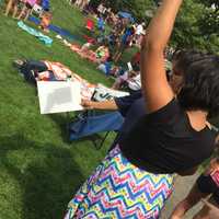 <p>A woman and her daughter use a pinhole postcard to cast a shadow of the eclipse onto a sheet of paper on Monday in Ballard Park.</p>