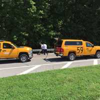 <p>Road crews clean up sand after a crash on Airport Road on Monday following a police chase from Greenwich, Conn.</p>