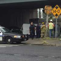 <p>Stamford police officers and firefighters check the scene of the rollover accident involving a commercial van.</p>