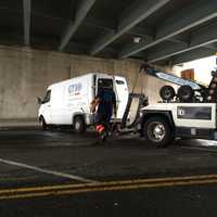 <p>A tow truck operator helps to clear the accident scene at about 11:45 a.m. Thursday.</p>