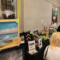 <p>Attendees appear near the silent auction table while placing their bids online. </p>