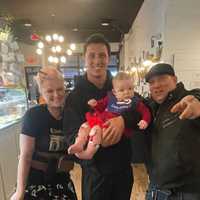 <p>Tommy DeVito holds Nino Coniglio and Shealyn Brand's daughter Penny, during a visit to make amends over an appearance mishap.</p>