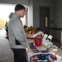 <p>Carlo Oropresa chats with Davin Lehman at his Driven By Heroes table, a service that provides non-emergency transportation to veterans. </p>