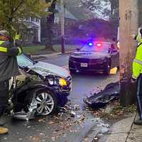 <p>Glen Rock police officer eyes the damaged pole as driver from All Points Towing begins to remove the Honda CRV after the crash on Maple Avenue.</p>