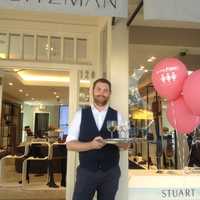 <p>Adam Gold welcomes shoppers to Stuart Weitzman with a refreshing beverage during the Go For Pink! fundraiser, Thursday, Oct. 6, 2016.</p>