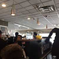 <p>Diners rush out away from the sprinkler at BLD Diner in Larchmont.</p>