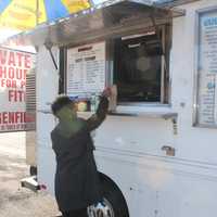 <p>Beverly Allen of New Milford purchases lunch from Mark Butlter at his Bergenfield-parked hotdog truck. </p>