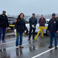 <p>A group of local law enforcement and government leaders deliver food and goodies to workers at a COVID-19 testing site.</p>