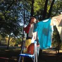 <p>Sue Horton, a member of the Trumbull Rotary Club, hangs T-shirts for The Clothesline Project.</p>