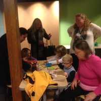 <p>Brenda Smith, Family &amp; Teacher Resource Center manager at Stepping Stones in Norwalk, looks on as participants in the Jumpstart Read for the Record program create paper bag puppets after reading &quot;The Bear Ate Your Sandwich.&quot;</p>