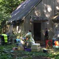 <p>A parrot is brought out of a building at 82 Newtown Turnpike in Weston on Friday. Officials seized hundreds of birds and snakes — both dead and alive — at the address this week.</p>