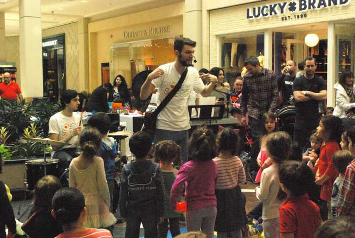 Kit from Song for Seeds leads children in song.