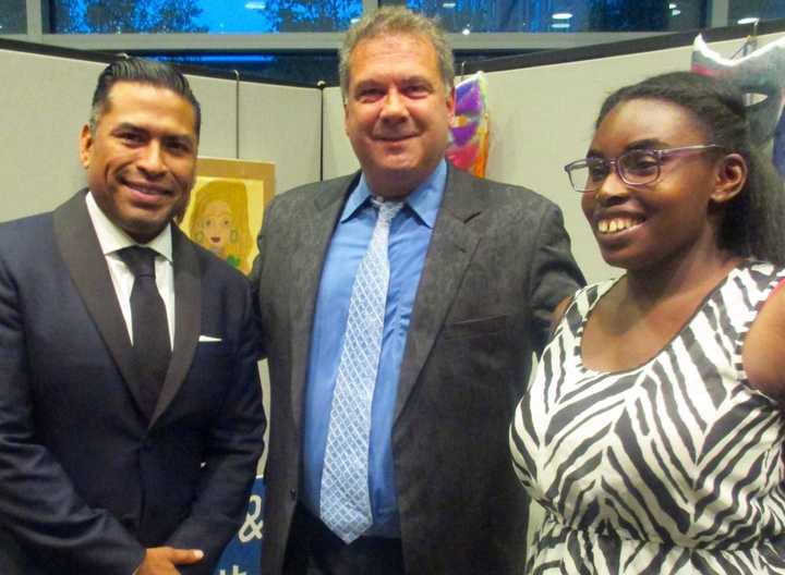 Left to right: Leake &amp; Watts Board President Jose Martin and Yonkers Mayor Mike Spano speak to Wilma, one of the individuals with disabilities in Leake &amp; Watts’ Day Habilitation Program whose works were on display at the Yonkers Public Library.