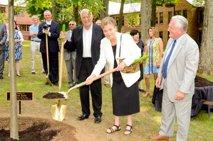 Andy Dolce (left) and Norwalk Mayor Harry Rilling (right) look on as Berenice Zullo (center) helps plant a tree in honor of her late husband and former Norwalk Mayor Frank Zullo.