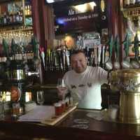 <p>A bartender at the Lazy Boy Saloon in White Plains prepares a beer flight.</p>