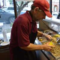 <p>Marc Silverberg scoops cookie dough in his shop on Rock Road.</p>