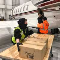 <p>Crew members with Signature Flight Support (South) received and unloaded the shipment Tuesday morning at Teterboro.</p>