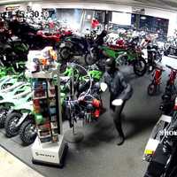 <p>Surveillance image of a suspect in the showroom of the motorbike store</p>