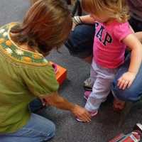 <p>Luann Rush of PedAgree Shoes checking the fit on 2-year-old Avery&#x27;s new pink sneakers. </p>