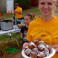 <p>Charissa Scarpa, of Midland Park, serving ollie bollen at the 50th Annual ECCR Country Fair, one of the few places to find the Dutch treat. </p>