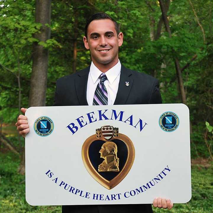 Dutchess County Legislator-elect Marc Coviello of Beekman holds one of the signs placed at every entry road into Beekman designating the town as a Purple Heart Community.