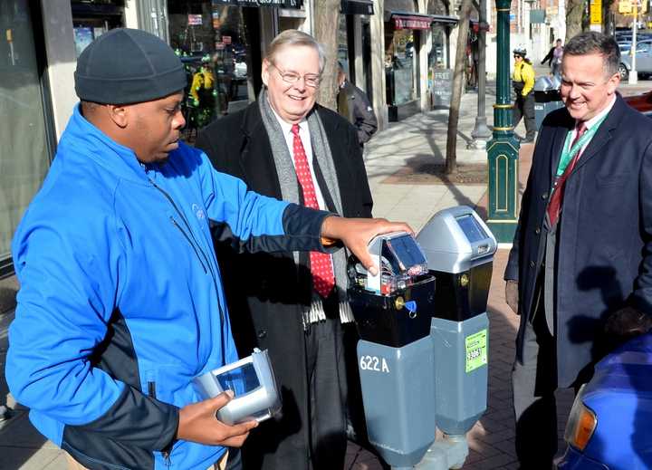 Mayor David Martin and Bureau Chief for Transportation Jim Travers watch as the final meter is installed on Bedford Street in Stamford on Wednesday.