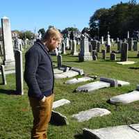 <p>Pastor Andy Kadzban of the Wyckoff Reformed Church surveys the damage done to century-old headstones in the church’s cemetery.</p>